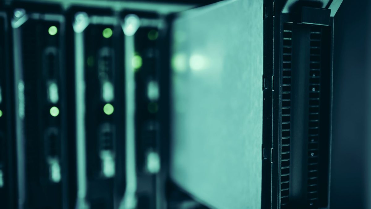 Racks de servidores modernos em um data center, iluminados em tons de azul.