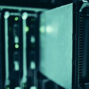 Racks de servidores modernos em um data center, iluminados em tons de azul.