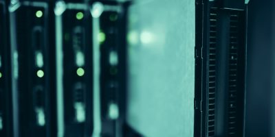Racks de servidores modernos em um data center, iluminados em tons de azul.