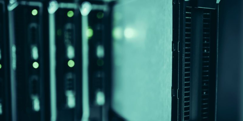 Racks de servidores modernos em um data center, iluminados em tons de azul.