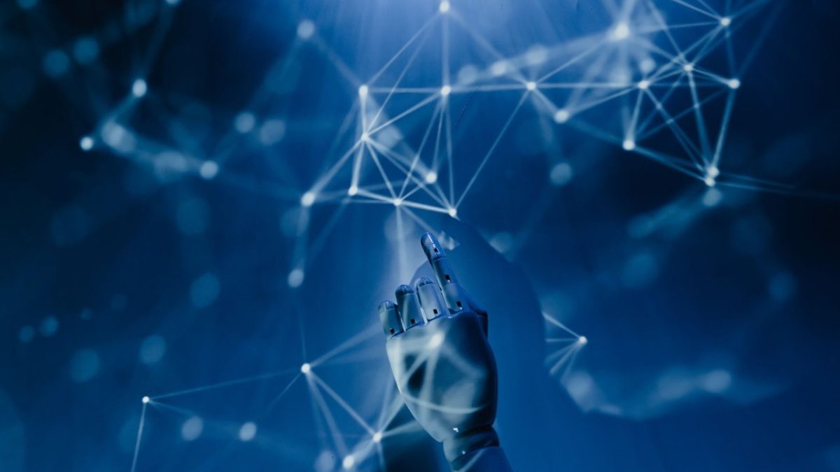 Mão robótica alcança uma rede digital azul, simbolizando o uso de inteligência artificial e sistemas automatizados.