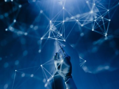 Mão robótica alcança uma rede digital azul, simbolizando o uso de inteligência artificial e sistemas automatizados.