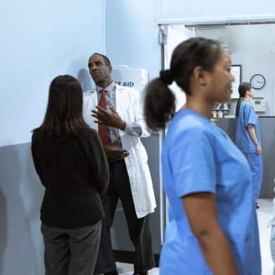 Médicos e enfermeiros conversam e analisam informações em um ambiente hospitalar.